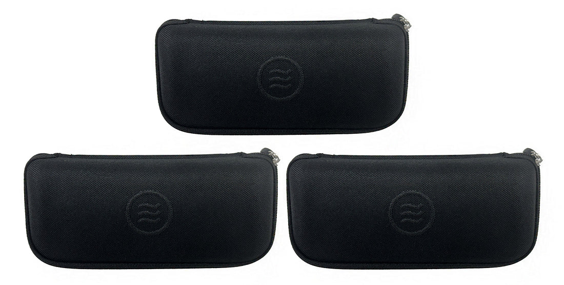 Lay-down of three black slim hard cases showing zippered closure and embossed tilde logo on textured waterproof polyester