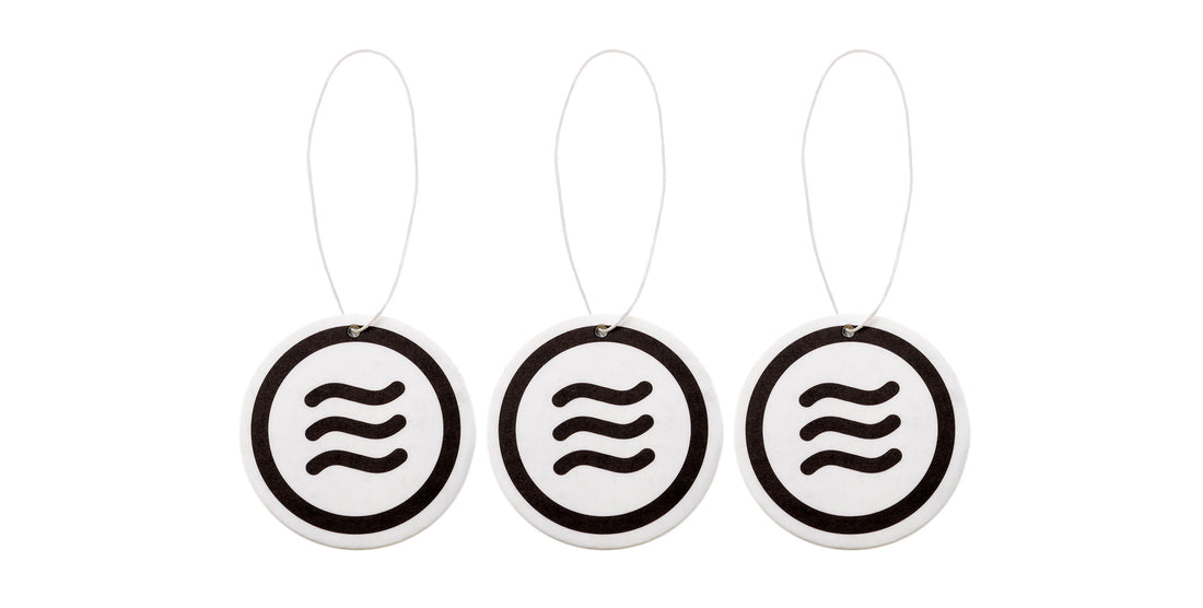Front view of three 2.5-inch Signature air fresheners showcasing black Neven tilde logo and hanging strings