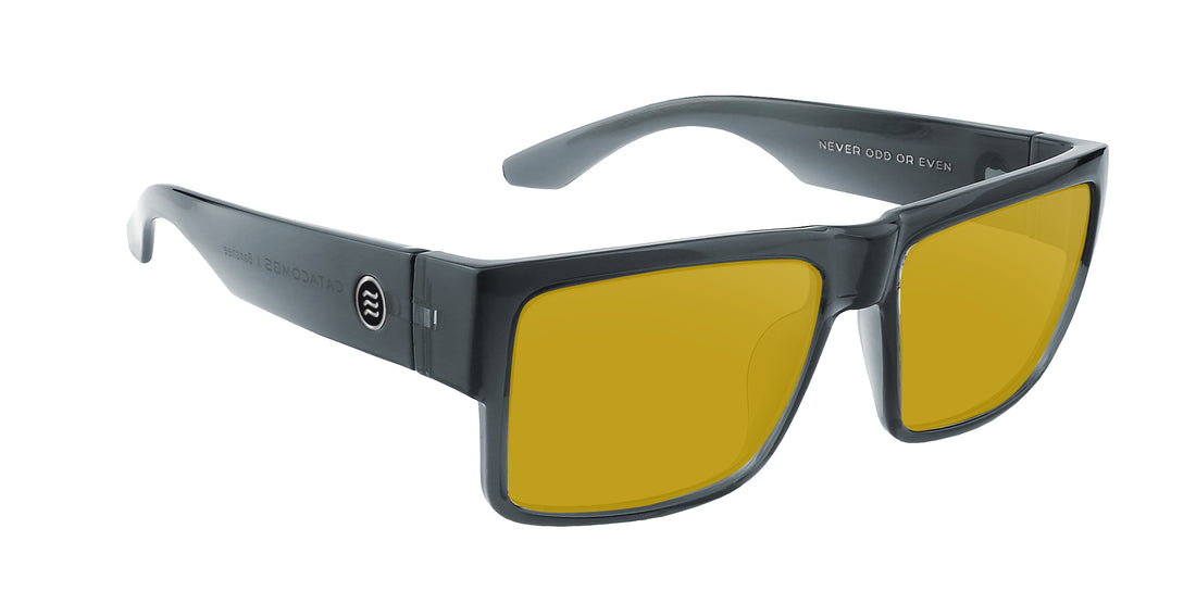 Close-up three-quarter view of Banshee prescription sunglasses showcasing transparent gray glossy frame and yellow Rx lenses on white background