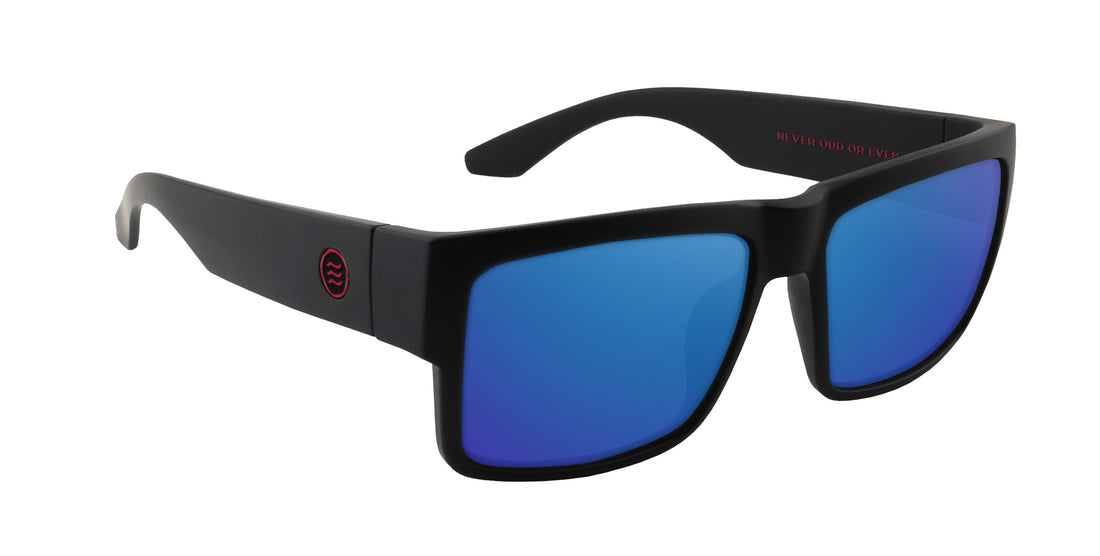 Three-quarter front view of Havoc prescription sunglasses showing matte black square frame, blue mirrored lenses, red temple logo on white background
