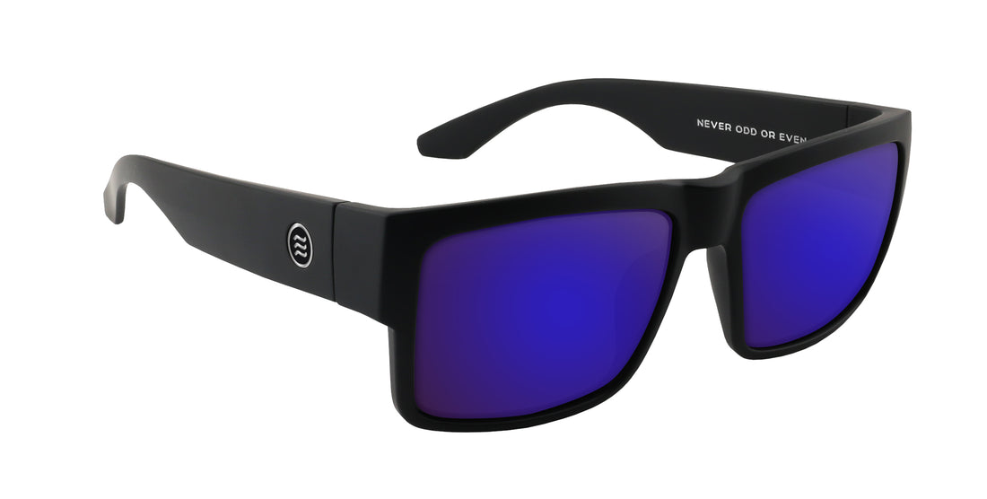 Three-quarter close-up of Relic sunglasses showing matte black X-Large frame, purple mirrored lenses, steel hinge on white