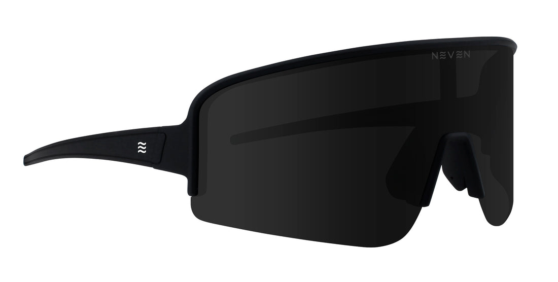 Front three-quarter view of Threshold sunglasses showcasing a black wraparound shield lens and slim black temples on a white background