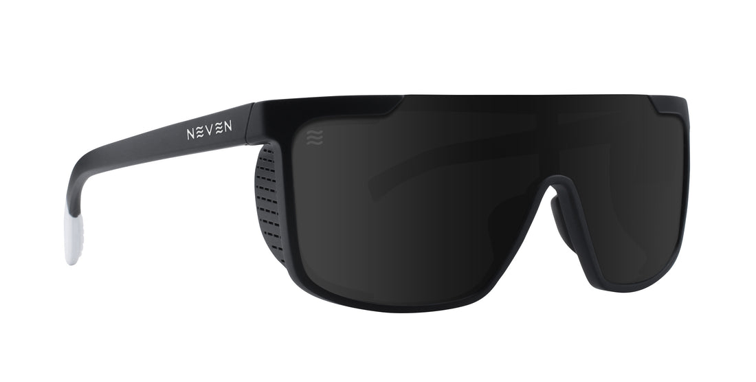 Front three-quarter view of Daywalkers sunglasses showcasing a pitch-black wraparound frame and dark lenses on a white background