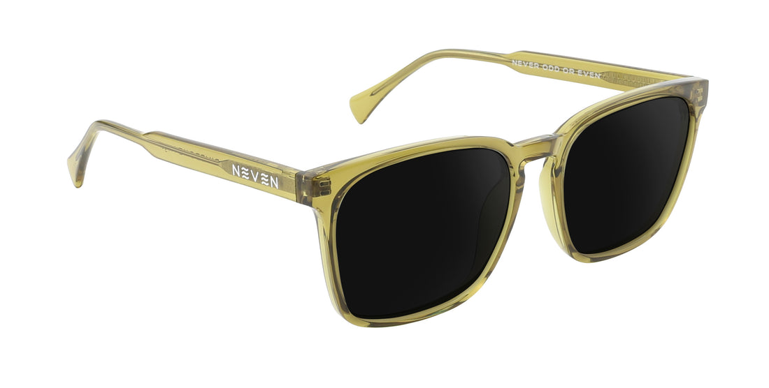 Angled close-up of Nigel sunglasses showing transparent olive green rectangular frame and dark prescription lenses on white background