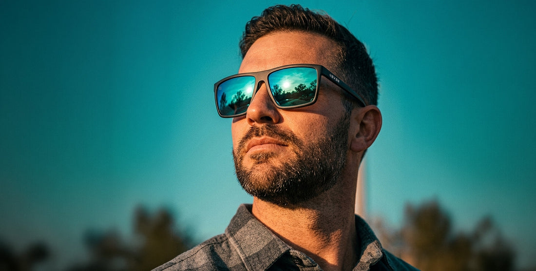 Man wearing black rectangular sunglasses with mirrored blue-green lenses outdoors