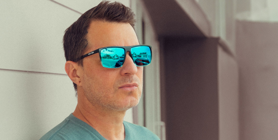 Man wearing black and blue Arizona polarized sunglasses with blue lenses in front of a building