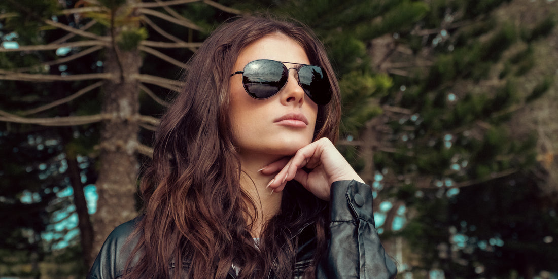 Woman wearing Nightfall black polarized aviator sunglasses outdoors among trees