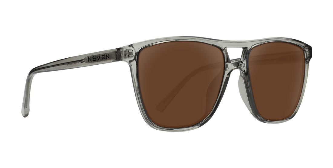 Three quarter view of Rip Tide prescription sunglasses with cool gray transparent frame, brown lenses, Neven logo on temple