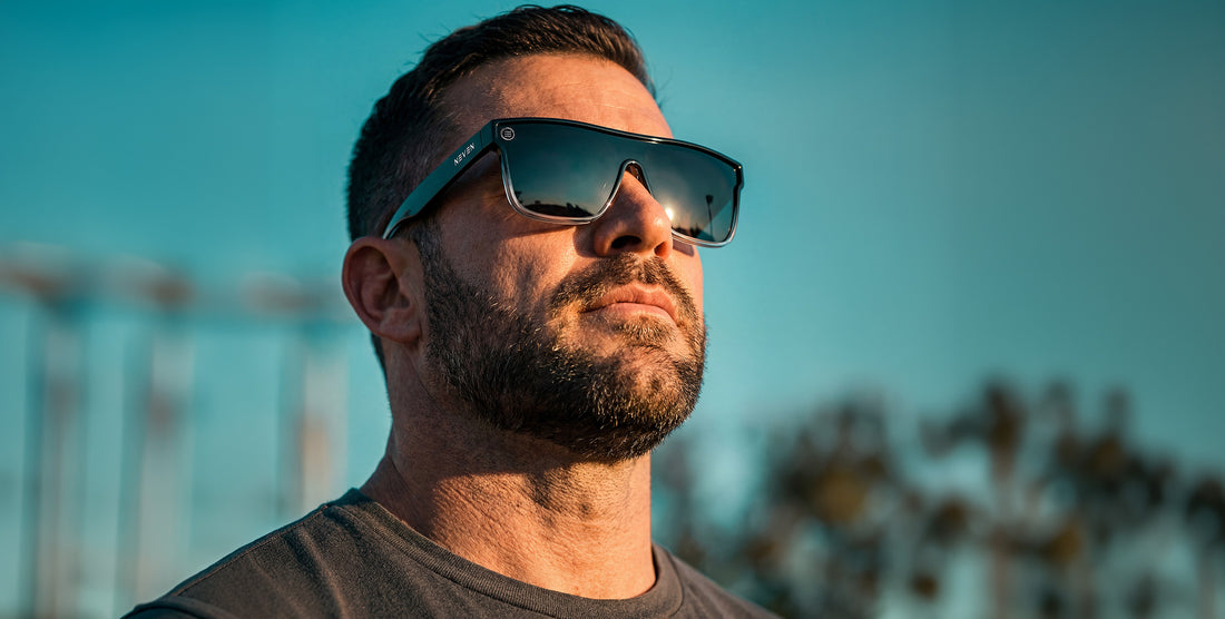 Man wearing Jordan XL oversized black-to-clear gradient sunglasses with polarized dark lenses against a turquoise sky