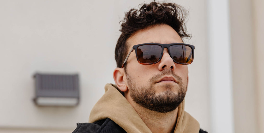 Low-angle close-up of Repeater sunglasses showing black frame with tortoiseshell accents and polarized brown lenses