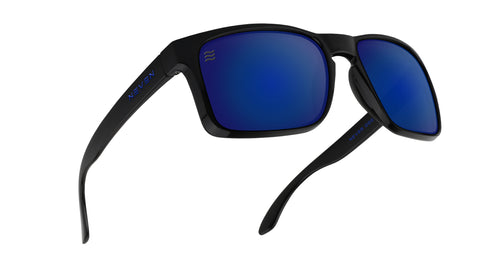 Three-quarter close-up of Blue Steel XL sunglasses showcasing glossy black TR90 frame and blue polarized lenses on white background