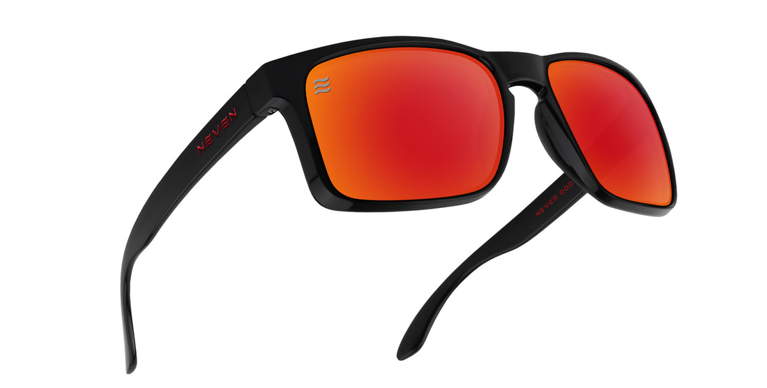 Angled view of John Wayne XL sunglasses showcasing glossy black frame and bold red mirrored polarized lenses on a white background