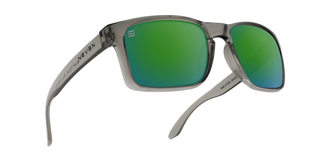 Three-quarter view of Stormy XL sunglasses with green polarized lenses and translucent gray oversized frame on white background