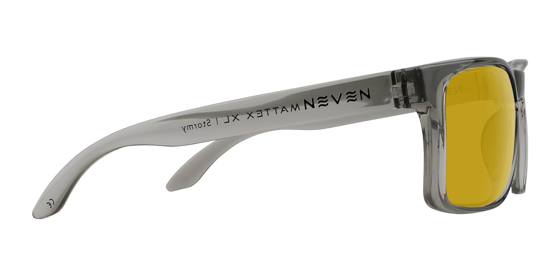 Side view of Stormy XL sunglasses showcasing transparent glossy gray oversized frame and yellow lenses on white background