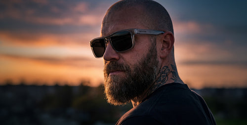 Man wearing sunglasses with a sunset in the background