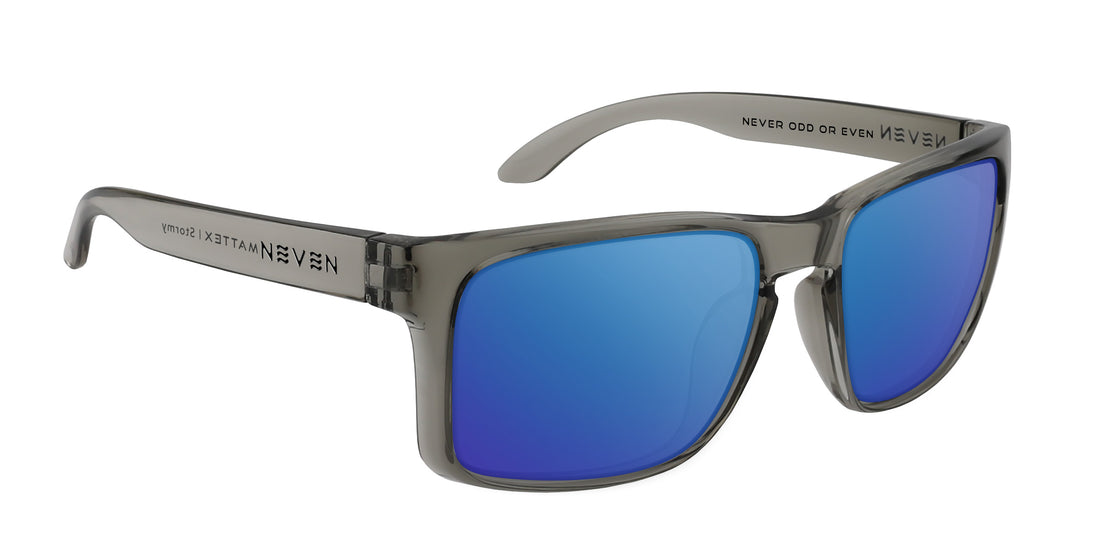 Three-quarter view of Stormy sunglasses showing transparent gray TR90 frame, hinge and blue mirrored lenses on white background