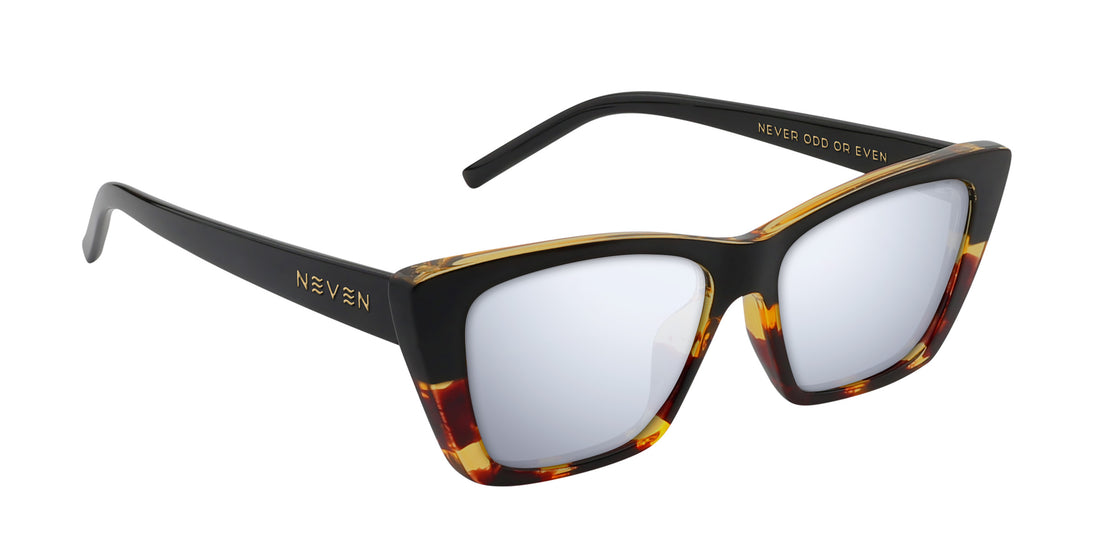 Angled view of Dusk cat-eye sunglasses with glossy black frame, tortoise-shell trim and gold logo on white background