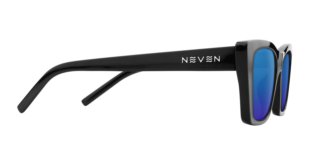 Side view of Noir prescription cat-eye sunglasses showing glossy black frame, silver temple logo and blue mirrored lenses on white background