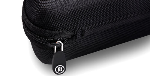 Close up of Signature Hard Case showing zippered corner, textured polyester surface, and Tilde logo on the zipper pull
