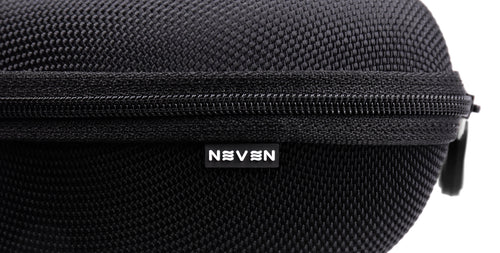 Close-up of Signature Hard Case showing zippered top, textured black polyester surface, and Neven tilde logo tag on white background