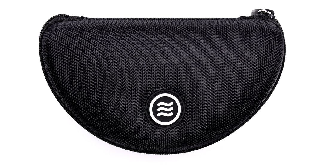 Close-up front of Signature Hard Case showing textured black polyester shell, zippered top, and Tilde logo on white background
