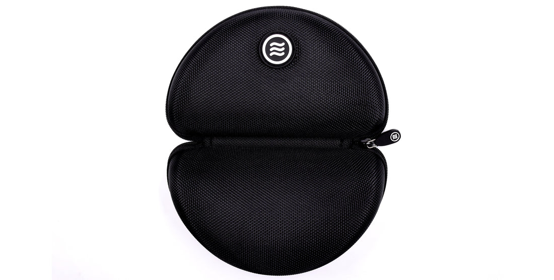 Top-down view of Signature Hard Case open showing zippered closure and Tilde logo on black textured polyester against white background