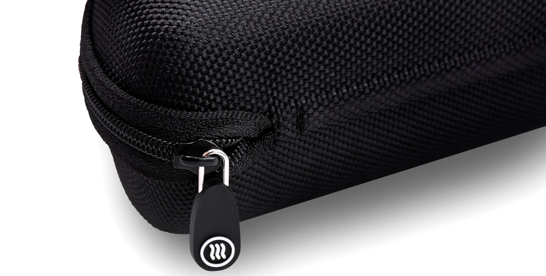 Close up of Signature Hard Case showing zippered corner, textured polyester surface, and Tilde logo on the zipper pull