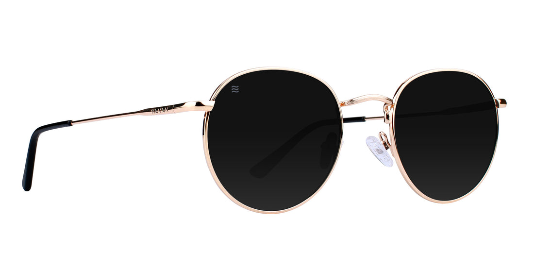 Front three-quarter view of Rae round polarized sunglasses showcasing rose gold frames and dark lenses on a white background