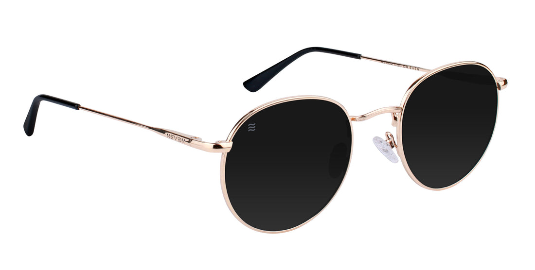 Angled close-up of Rae sunglasses showcasing small gold metal round frames and black polarized lenses on white background