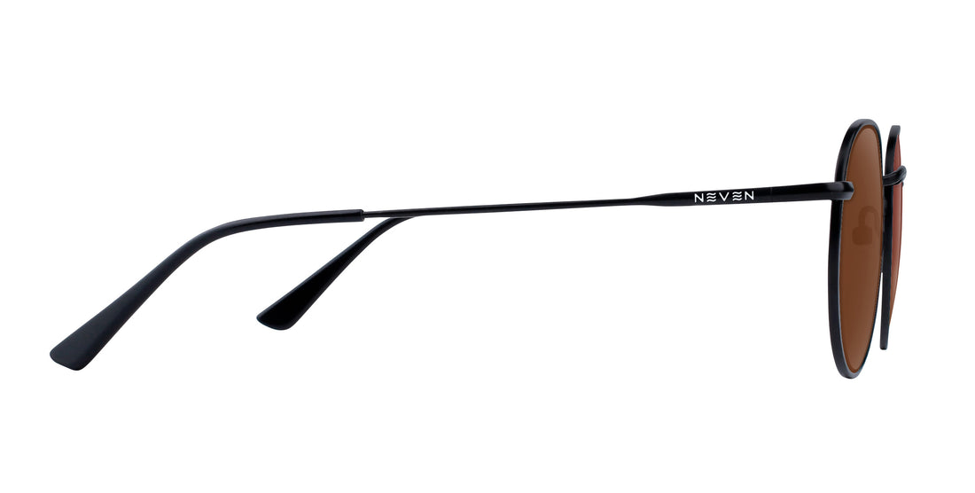 Side view of Saint prescription aviator sunglasses showing thin black metal temples with Neven logo and brown lenses on white
