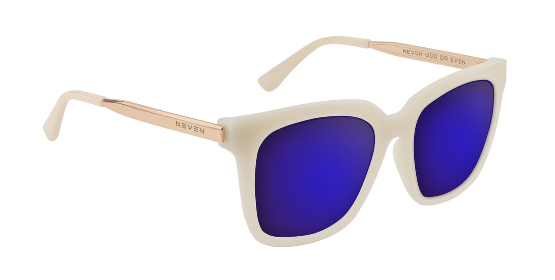 Front-right close-up of Sand Dollar sunglasses showcasing white greige oversized frame, gold engraved arms, and purple mirrored lenses