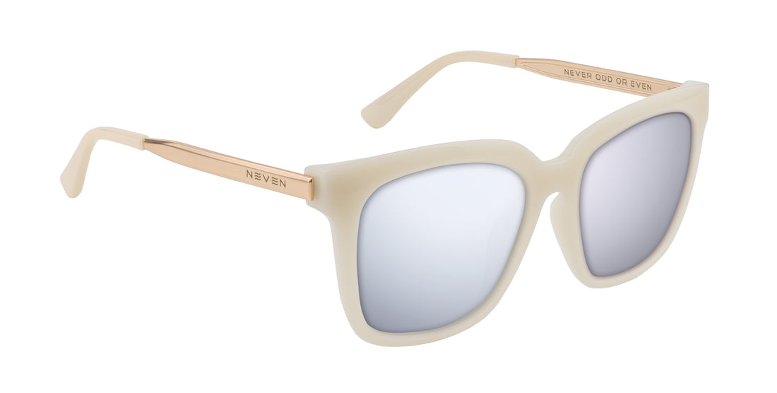 Close-up angled view of Sand Dollar sunglasses showcasing milky white greige oversized frame and gold engraved metal arms on white background