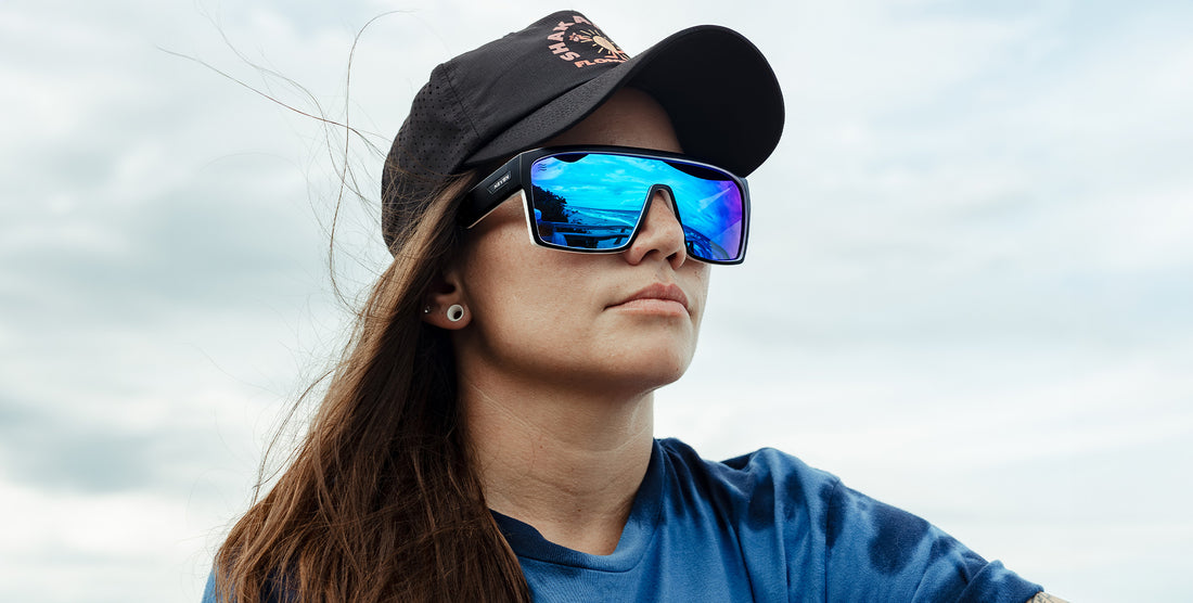 Woman wearing Spanish House polarized sunglasses with blue mirrored lenses outdoors under a cloudy sky