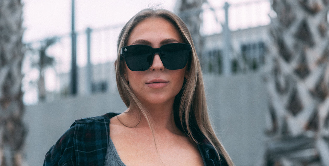 Woman wearing large Atlantis Black Cat Eye Polarized sunglasses in an urban setting