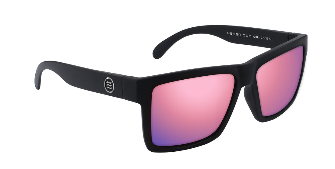 Angled close-up of Ace XL sunglasses showing oversized matte black TR90 frame and pink mirrored prescription lenses on white