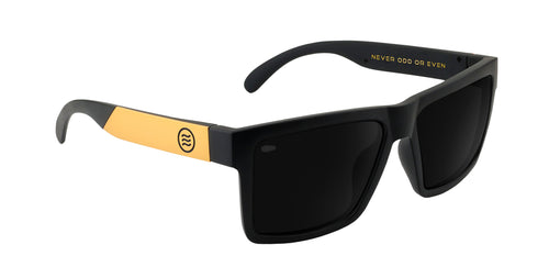 Angled close-up of Prospector XL sunglasses showing black polarized lenses and gold temple accents on white background