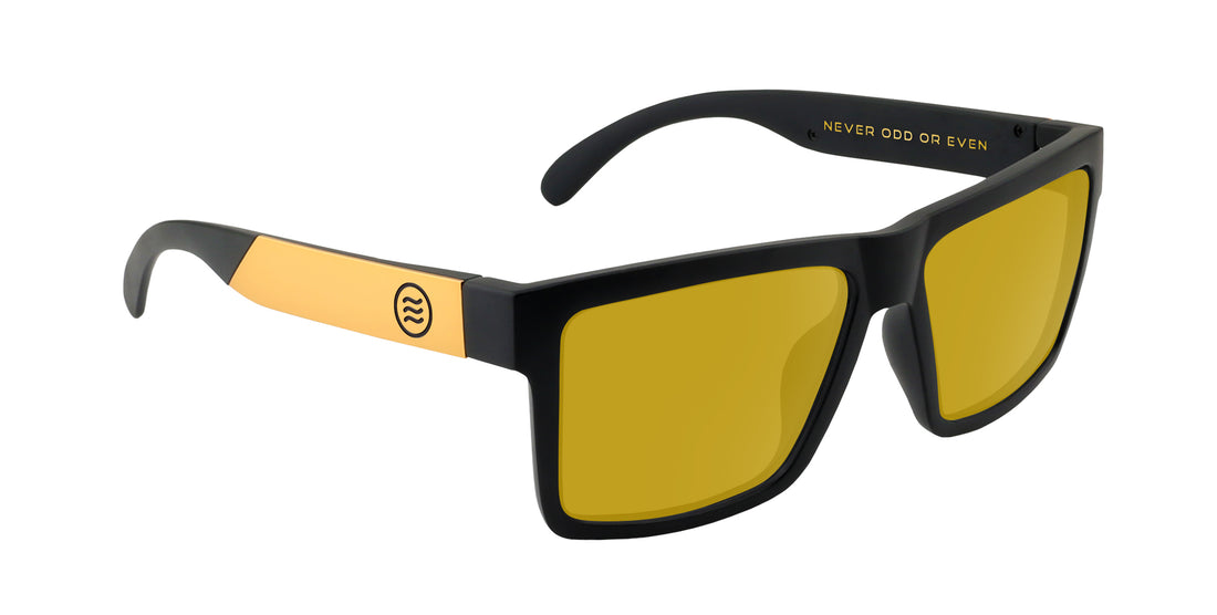 Close-up three-quarter view of Prospector XL Rx sunglasses with matte black frame, gold temples, and yellow lenses