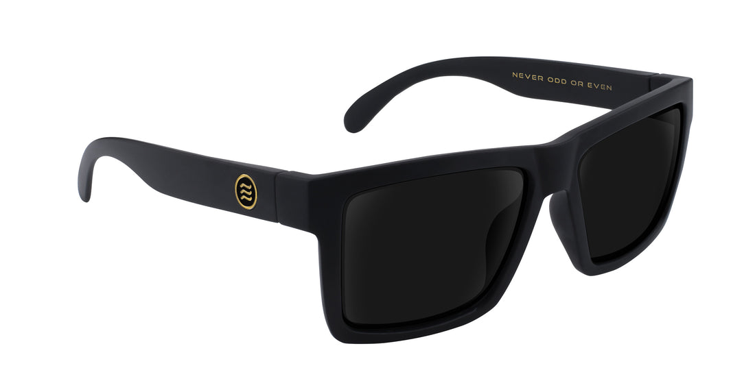 Angled close-up of Sentry XL sunglasses with matte black frame, gold temple logo and dark Rx lenses on white background