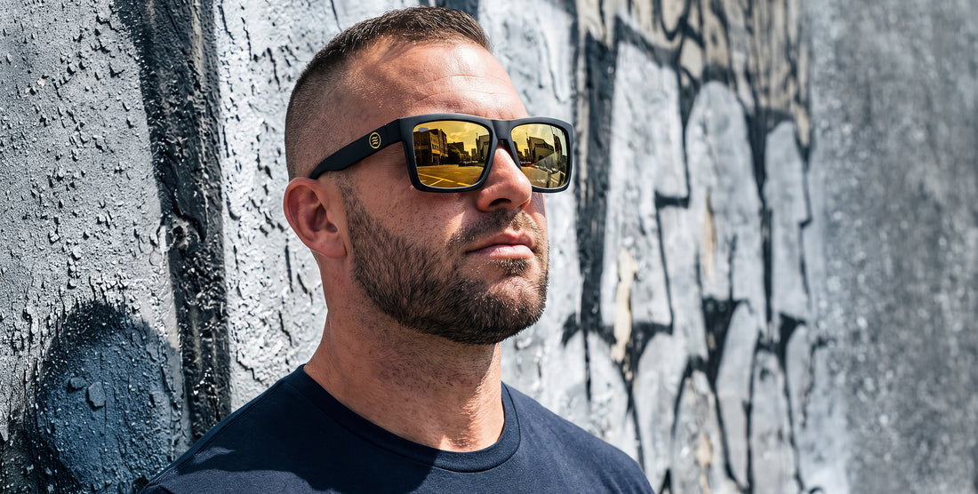 Right three-quarter view of Sentry XL sunglasses with X-Large matte black frame and gold polarized lenses, graffiti wall