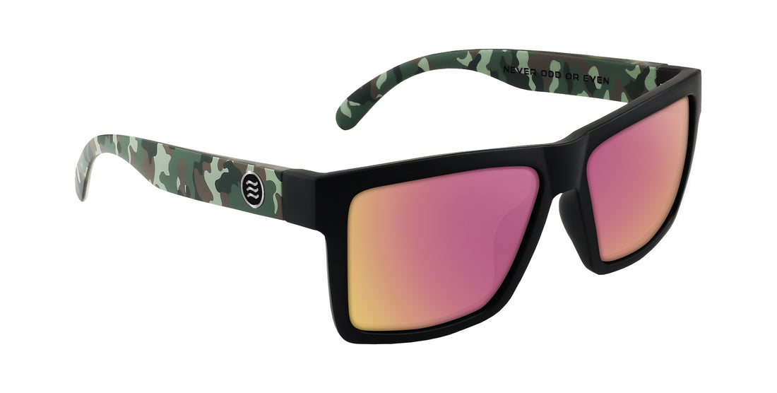 Three-quarter view of Bad Company sunglasses showcasing matte black frame, camo-pattern temples and rose-pink mirrored prescription lenses on white background
