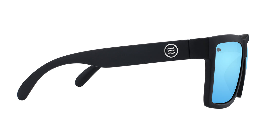 Side view of Montauk polarized sunglasses showcasing matte black temple, round logo, and blue mirrored lens on white background
