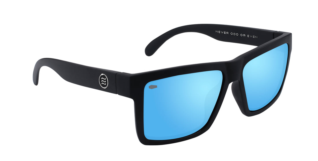 Three quarter close up of Montauk sunglasses showing matte black frame, blue mirrored polarized lenses and temple logo on white background
