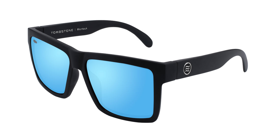 Three-quarter view of Montauk polarized sunglasses showcasing matte black square frame and blue mirrored lenses on white background