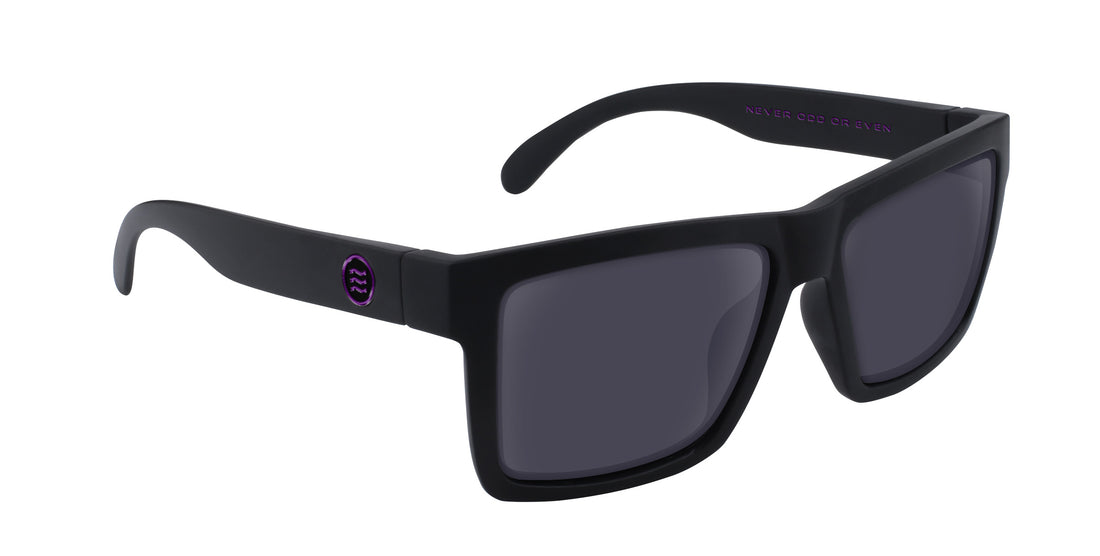 Angled close-up of Nightshade sunglasses with matte black frame, dark gray lenses, and purple temple logo on white background