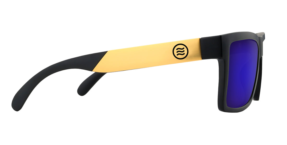 Right-side close-up of Prospector sunglasses showing matte black frame, gold metal temple with circular logo and purple mirrored lenses on white background