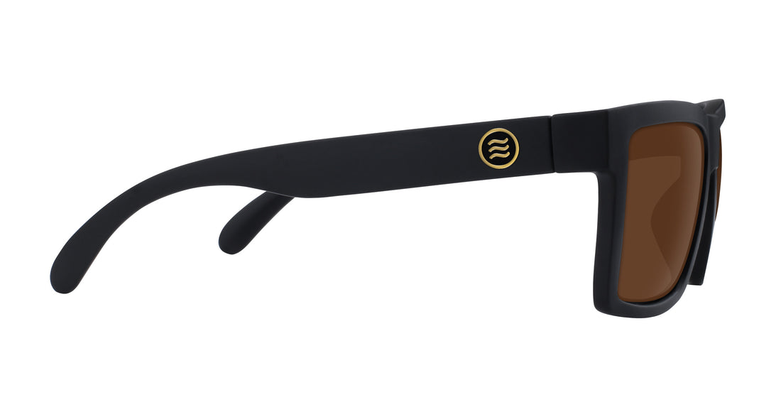 Side view of Sentry sunglasses, matte black frame with gold temple logo and brown lenses on white background