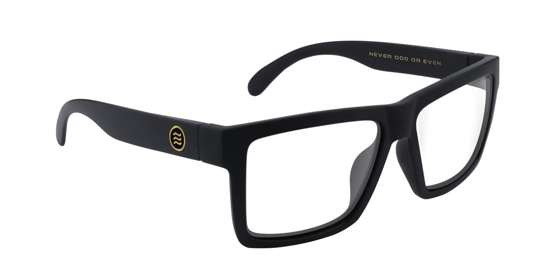 Angled close-up of Sentry Rx sunglasses with matte black frame, clear lenses and gold temple emblem on white background
