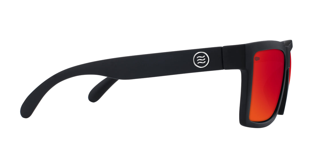 Side view of Supernova sunglasses showcasing matte black large frame, red-to-orange polarized lenses, and Tombstone logo on temple on white background