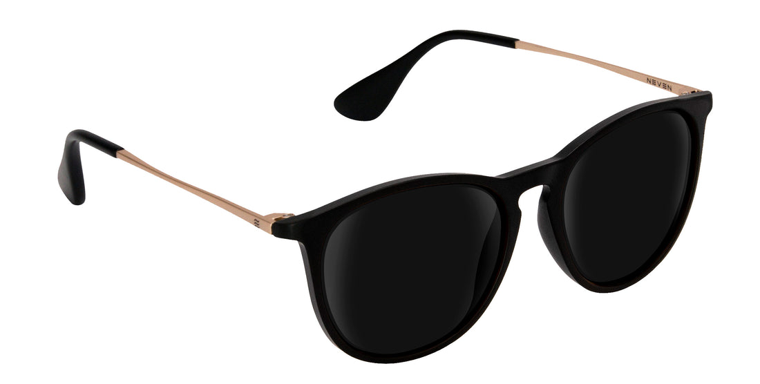 Close up three quarter view of Goldie Lux prescription sunglasses showcasing matte black round frame and slim gold tone metal temples on white background
