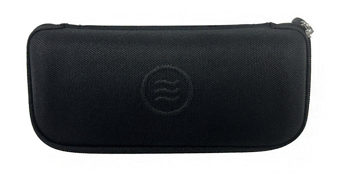 Lay-down of black slim hard case showing zippered closure and embossed tilde logo on textured waterproof polyester
